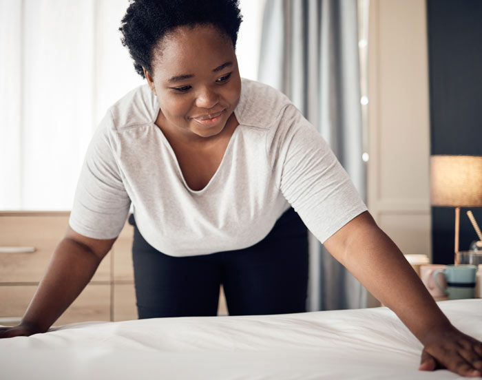 A young woman making her bed